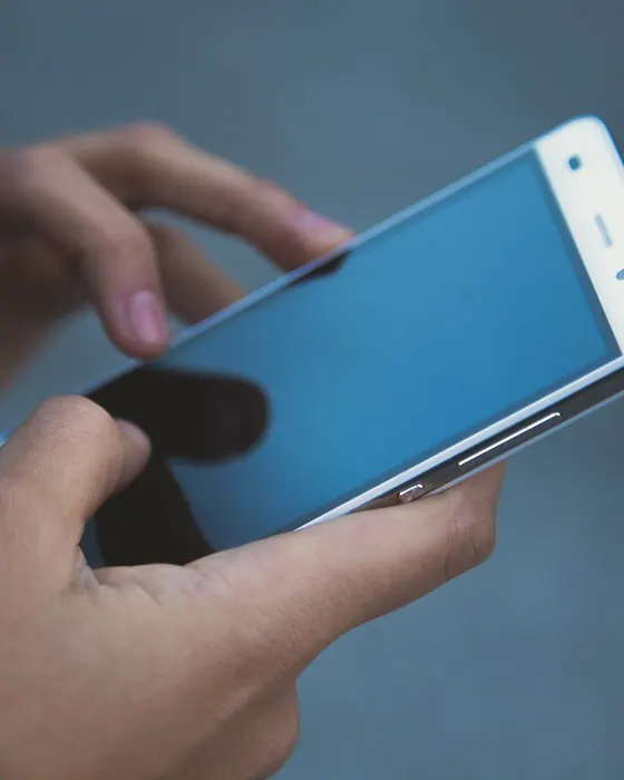 Personne qui s’interroge, téléphone en main