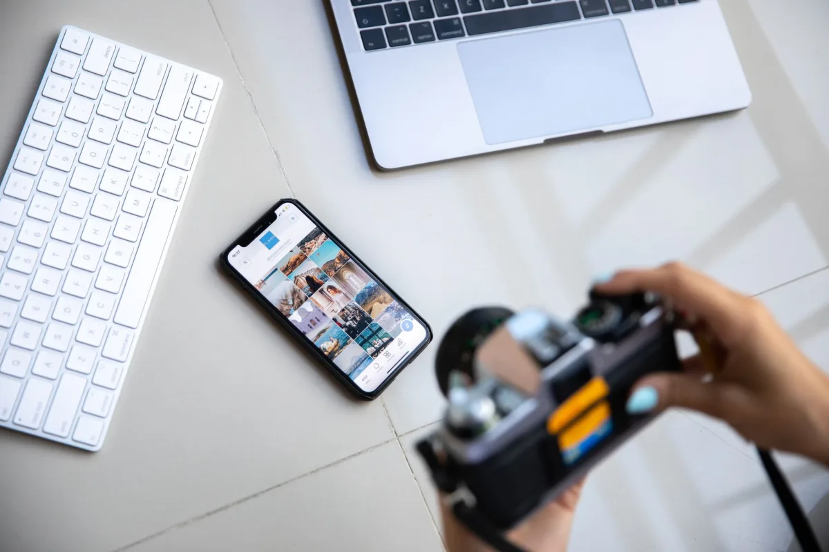 Une personne retouchant des photos sur son téléphone, dans un café