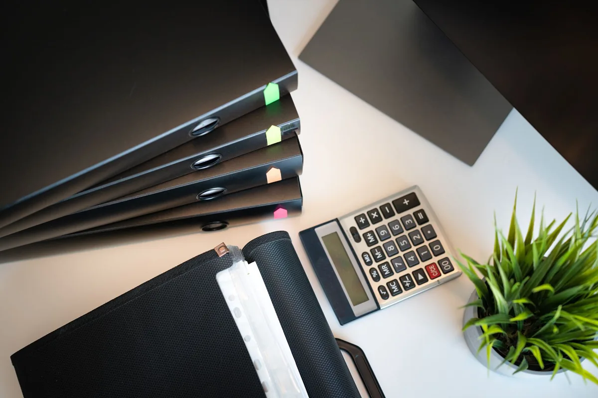 Un carnet ouvert et un ordinateur portable sur un bureau