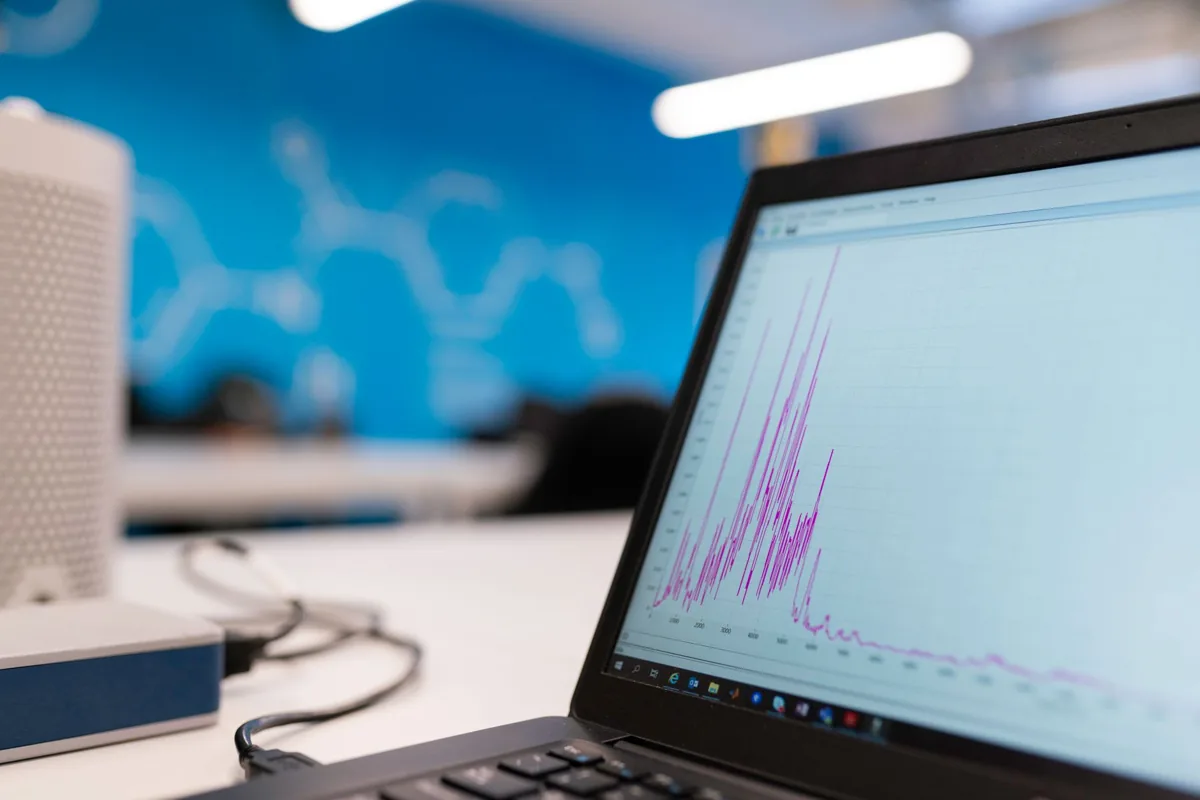 Une main qui pointe une courbe de statistiques sur un graphique imprimé