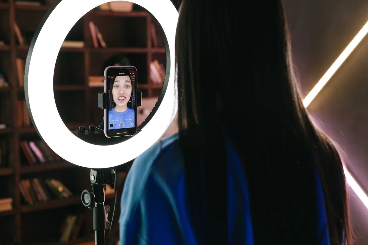 Une créatrice de contenu filme une vidéo verticale avec un trépied