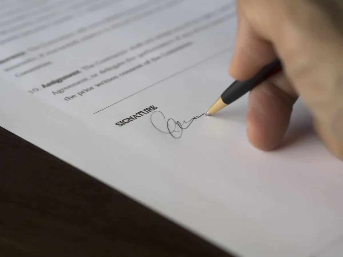 Un contrat signé au stylo sur une table de travail